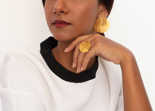 Minimalist gold-plated jewelry set featuring large circular earrings and a matching ring.