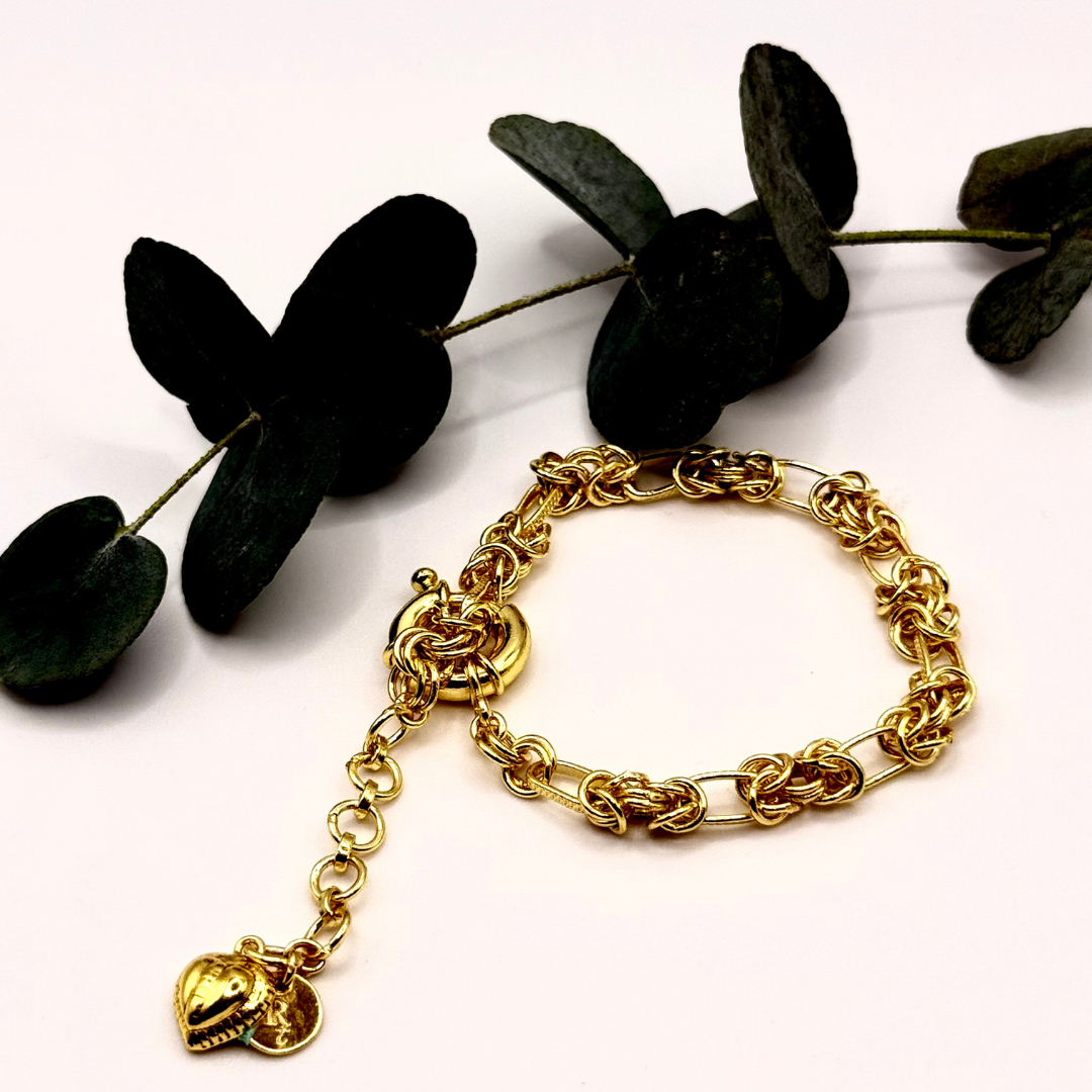 Gridlocked Bracelet — chunky 18k gold-plated chain bracelet with knot-link pattern and heart charm detail.