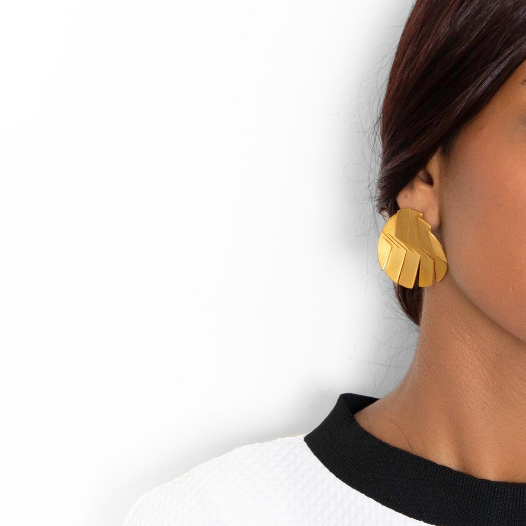 Statement gold plated earrings in a fan-cut circular shape with textured grooves from the LIQUIFY collection