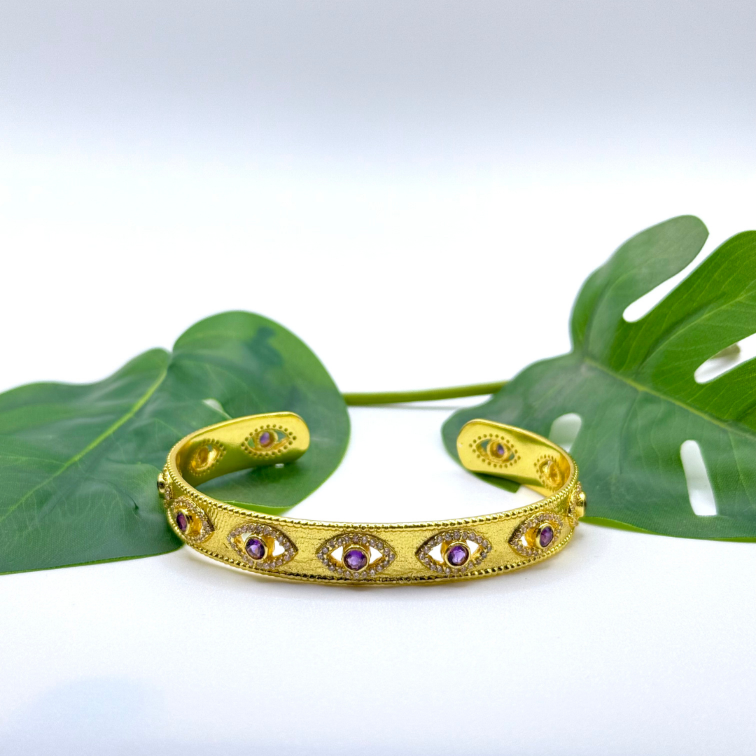 On Guard Hand Cuff in 18k gold plating with purple stones and evil-eye inspired detailing
