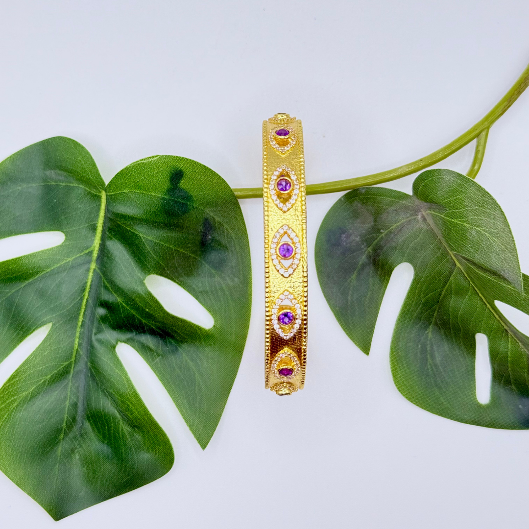 On Guard Hand Cuff in 18k gold plating with purple stones and evil-eye inspired detailing