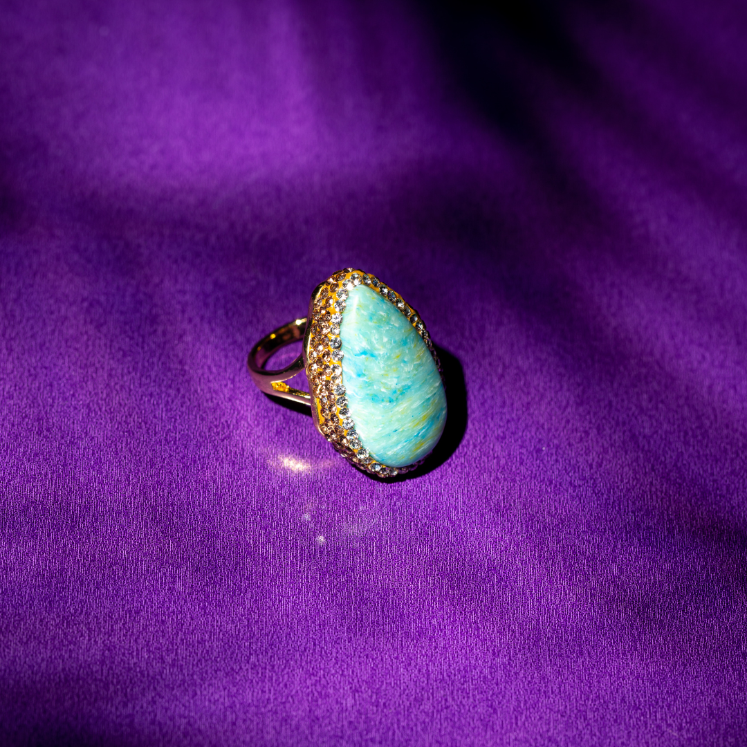 Teardrop ring with cloudy green stone and gold plated setting.