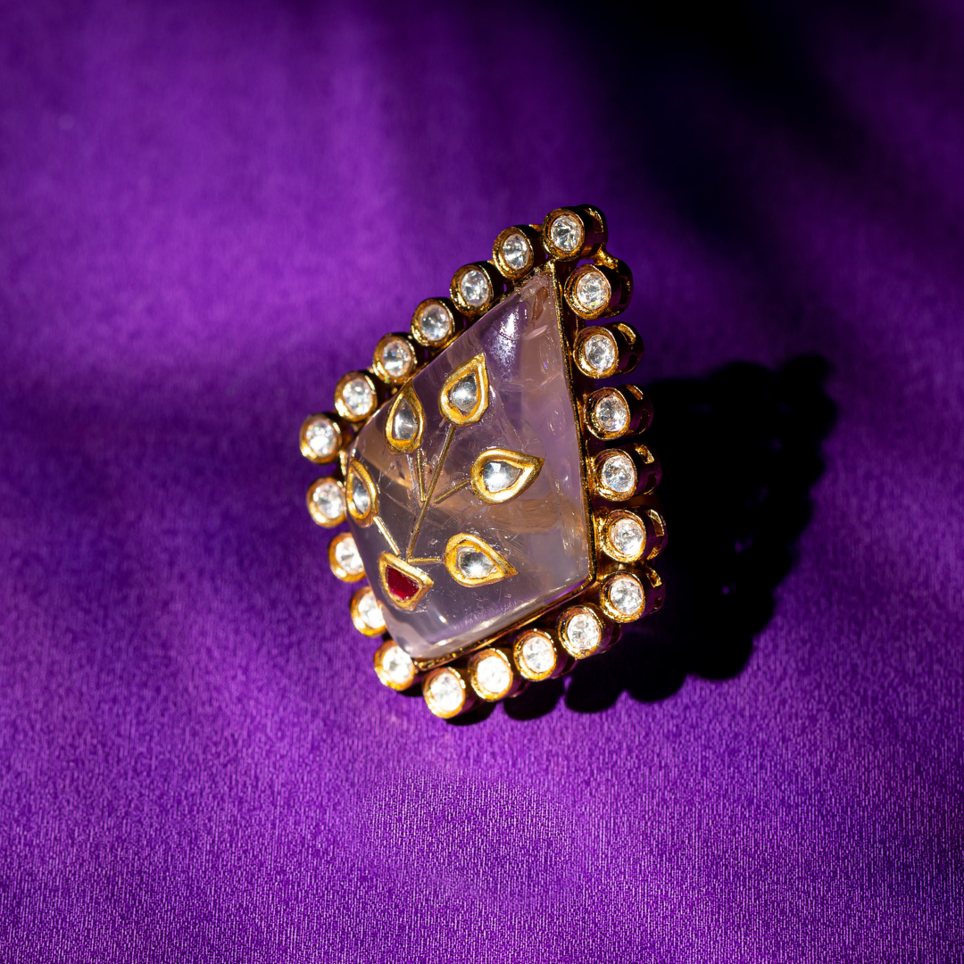 Triangle-shaped polki ring with red enamel in gold finish.