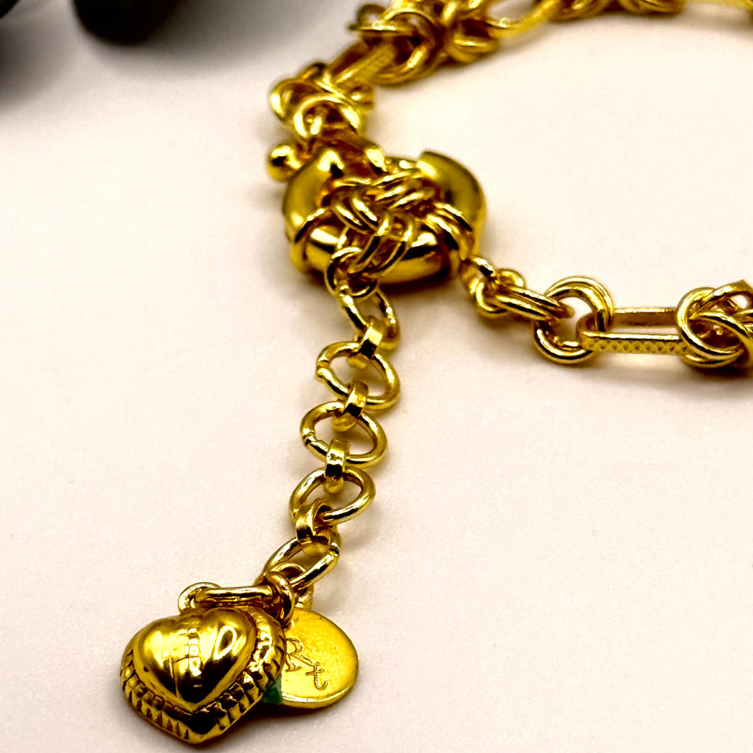 Gridlocked Bracelet — chunky 18k gold-plated chain bracelet with knot-link pattern and heart charm detail.
