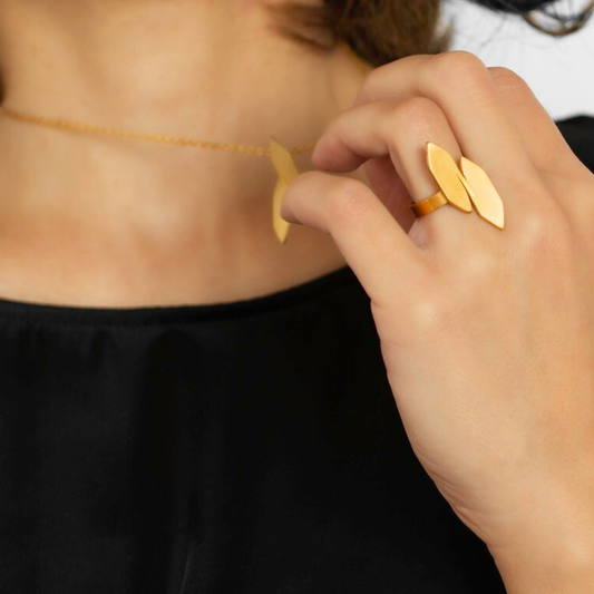 Gold plated modular ring with twin sculptural panels from transformable jewelry collection, styled with matching pendant.