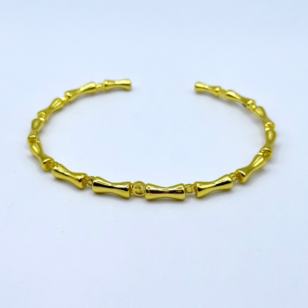 Liner Bracelet — 18k gold-plated bracelet with bamboo-style links and sleek, structured finish.
