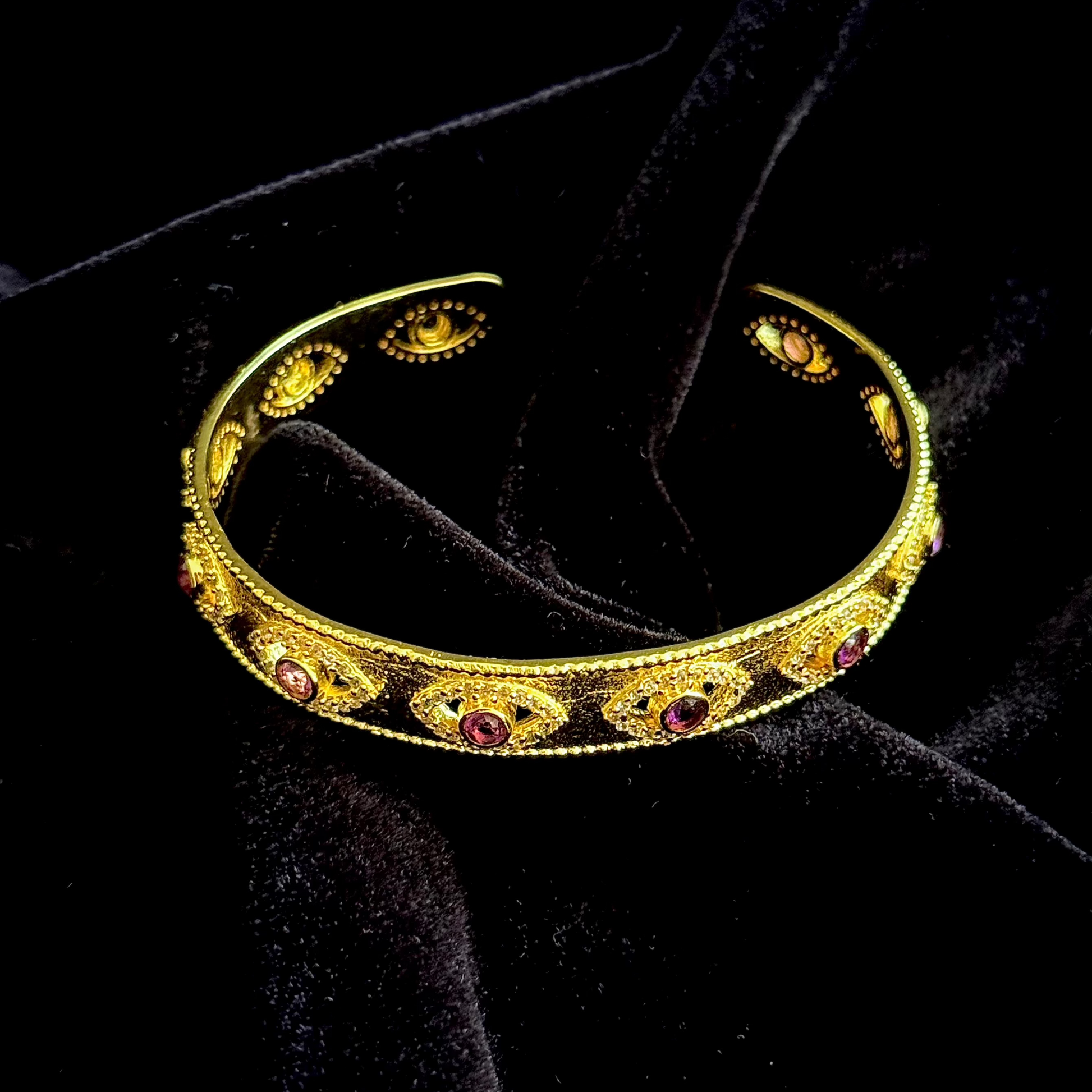 On Guard Hand Cuff in 18k gold plating with purple stones and evil-eye inspired detailing
