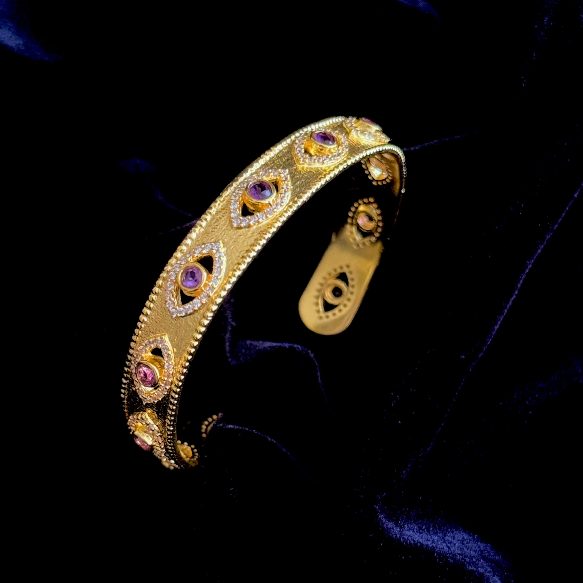 On Guard Hand Cuff in 18k gold plating with purple stones and evil-eye inspired detailing


