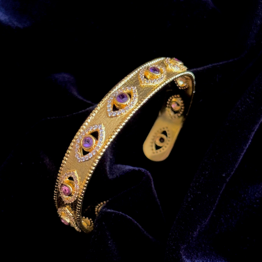 On Guard Hand Cuff in 18k gold plating with purple stones and evil-eye inspired detailing

