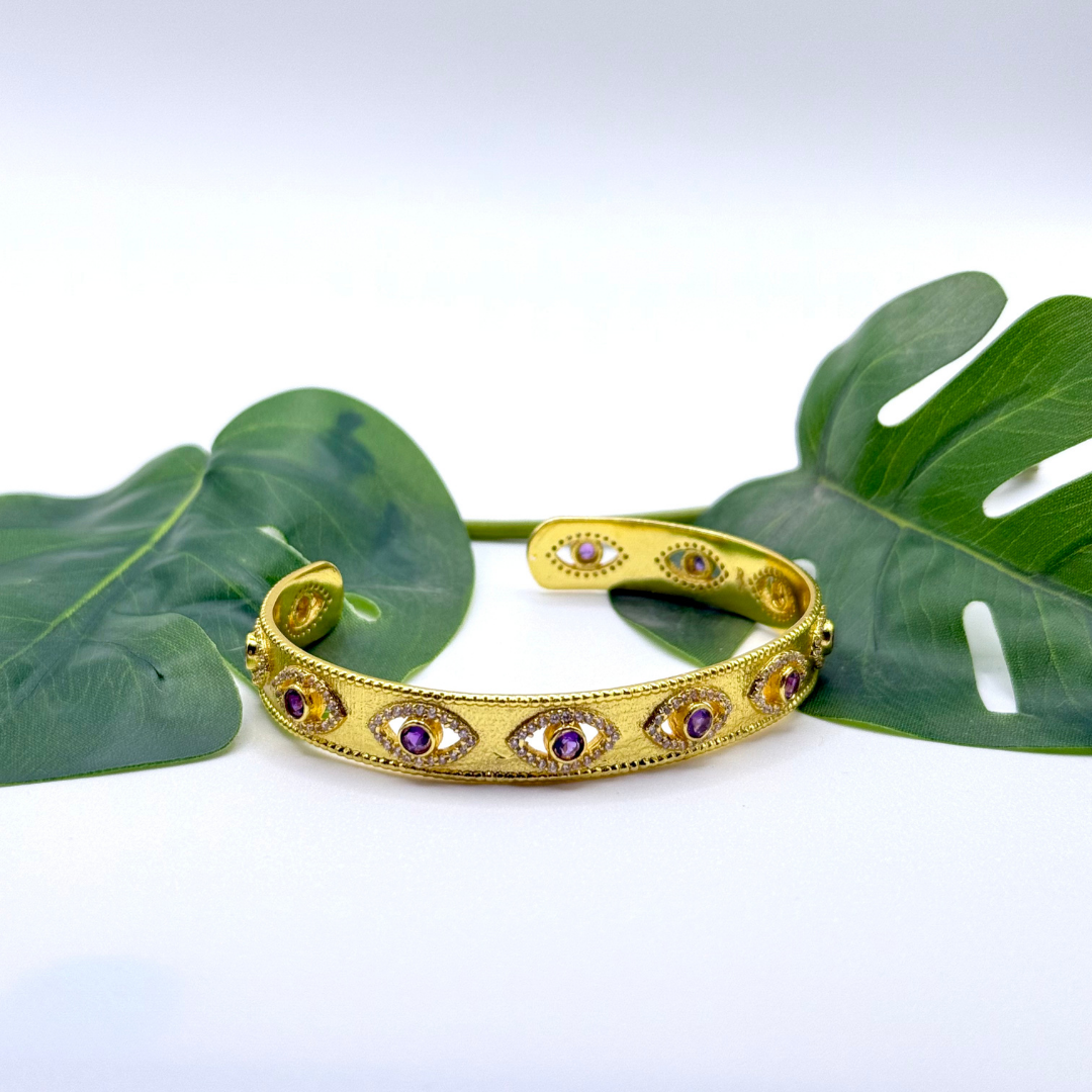 On Guard Hand Cuff in 18k gold plating with purple stones and evil-eye inspired detailing
