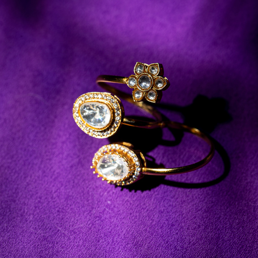 Gold plated double finger crystal ring with round and teardrop stones

