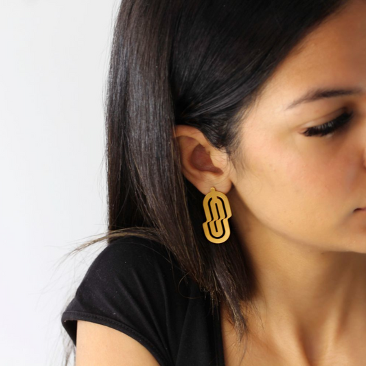 Trompe L’oeil gold plated brass earrings with sculptural cutouts, part of bold fashion jewelry collection inspired by optical illusions