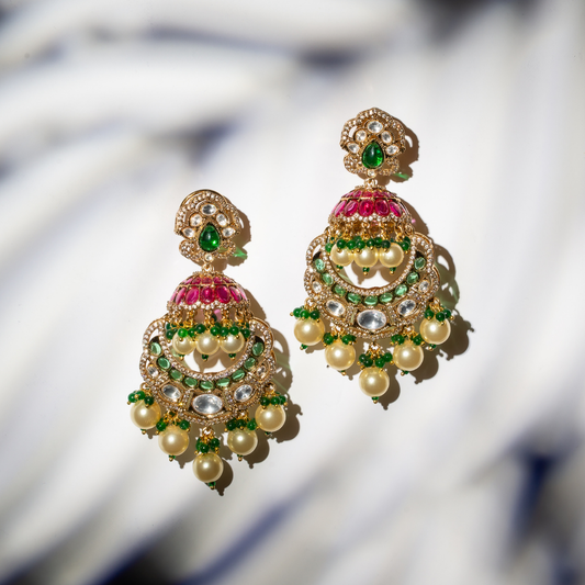 the khaas earrings with gold plated jhumka earrings with red and green stone work and ghungroo pearl drops

