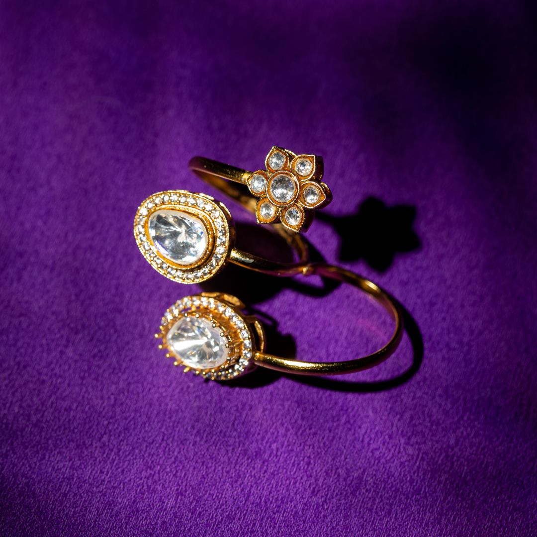 Gold plated double finger crystal ring with round and teardrop stones

